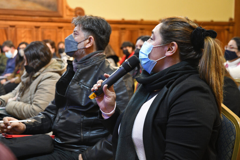Asistentes a la Jornada de Orientadores, de pie, entre ellas una persona con un micrófono. Todas las personas con mascarillas.
