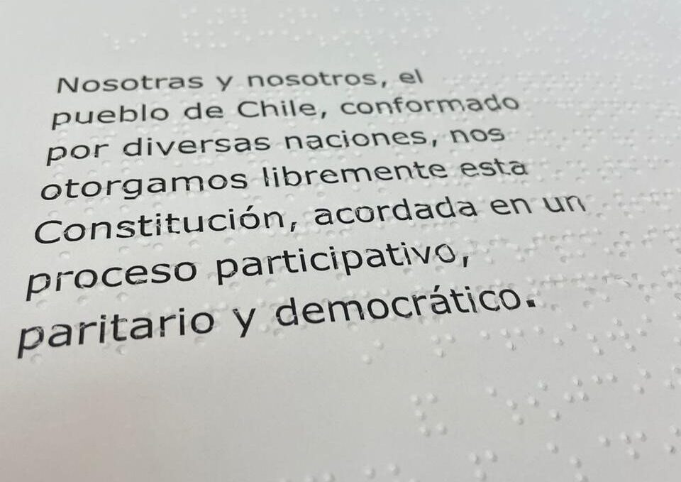 Fotografía. Primer plano del primer artículo de propuesta de nueva Constitución en Braille y macrotipo.
