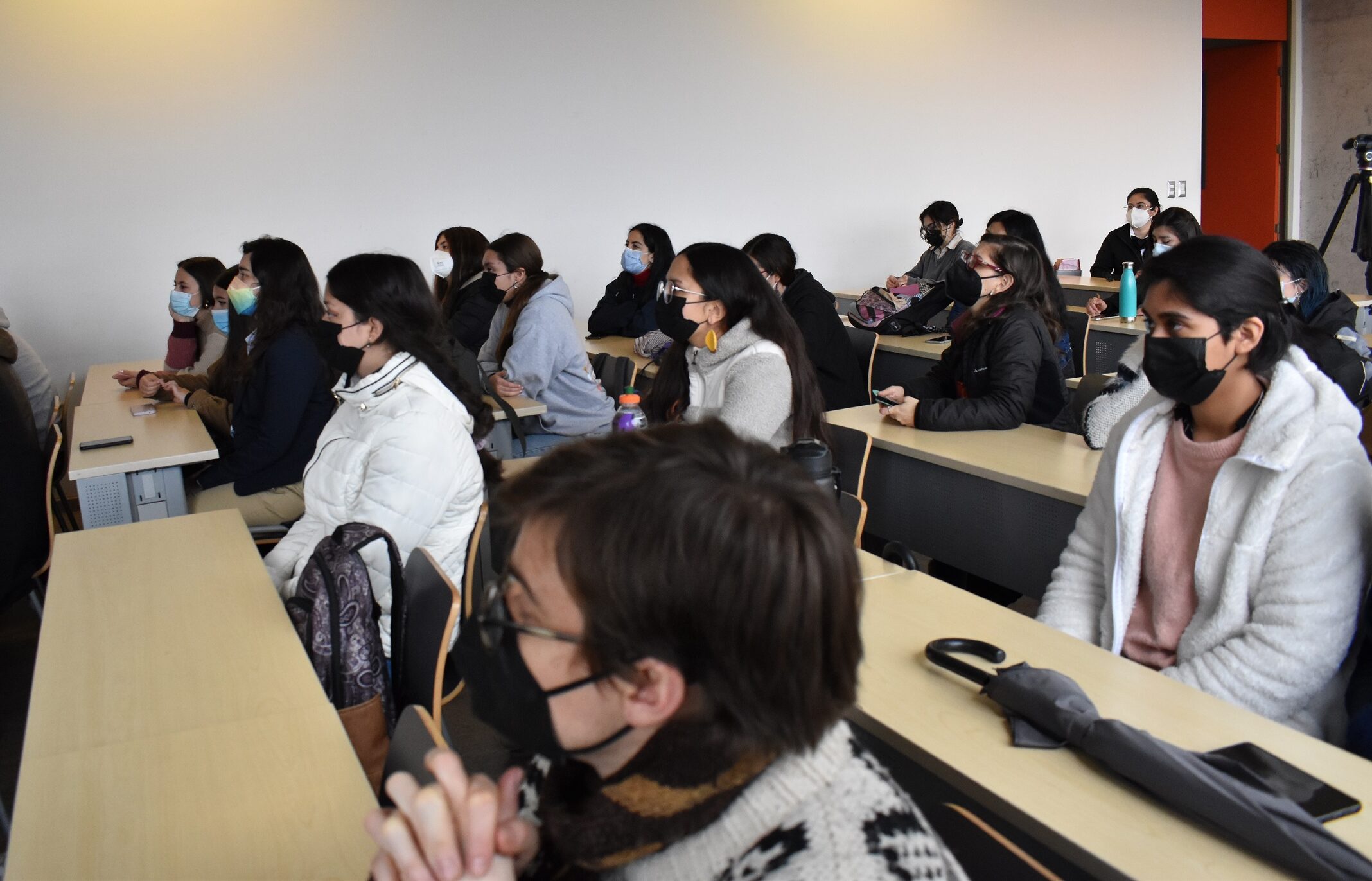 Fotografía. Estudiantes participantes, vista lateral de la sala.