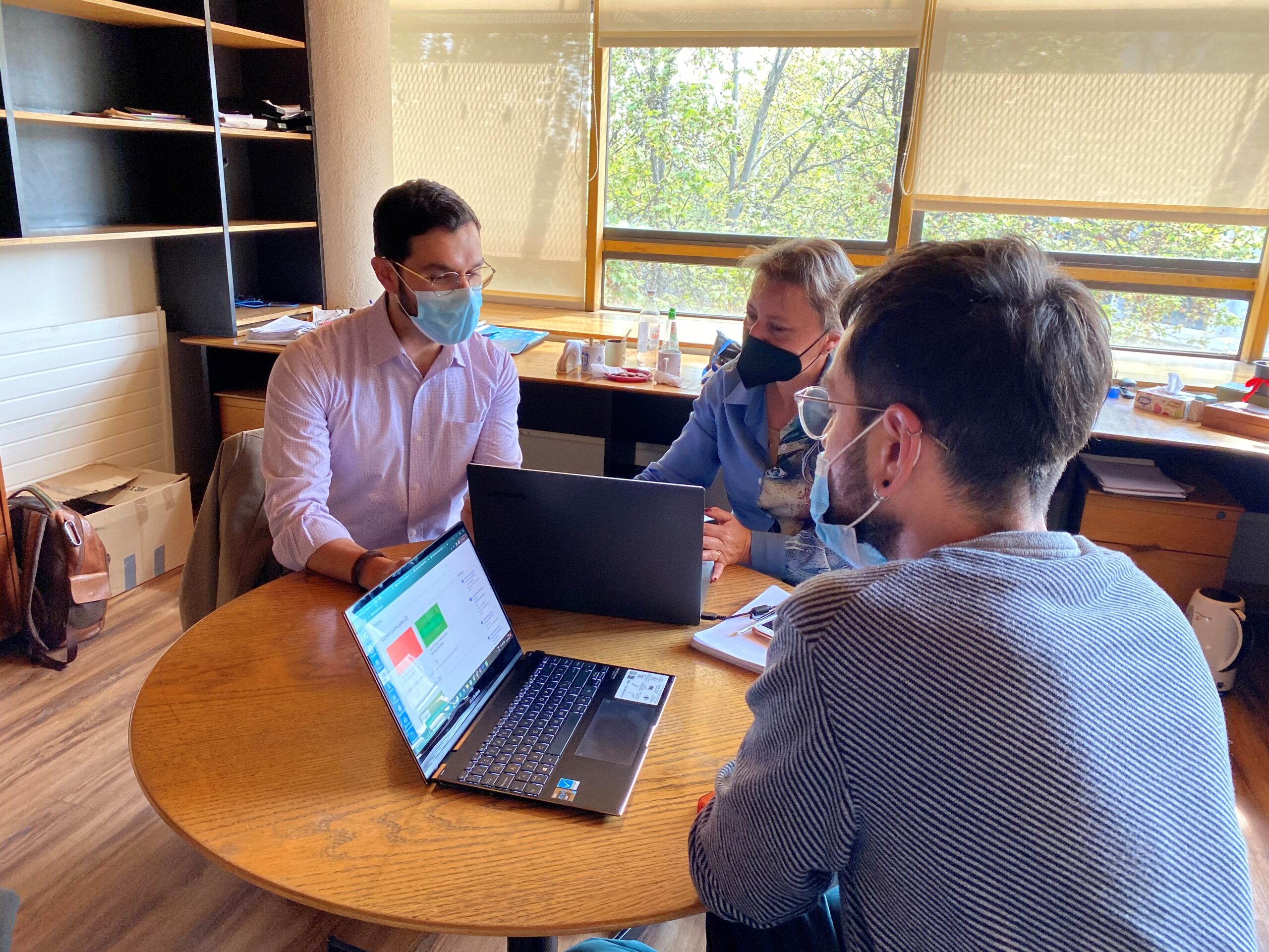 Fotografía. Docentes Cristian Núñez y Ana Gutiérrez sentados en una mesa circular junto a asesorados
