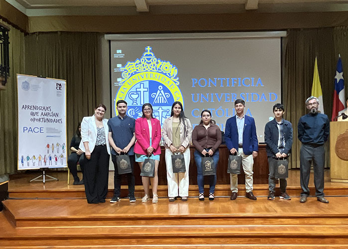Fotografía de un grupo de personas sosteniendo unas bolsas en sus manos, en un escenario