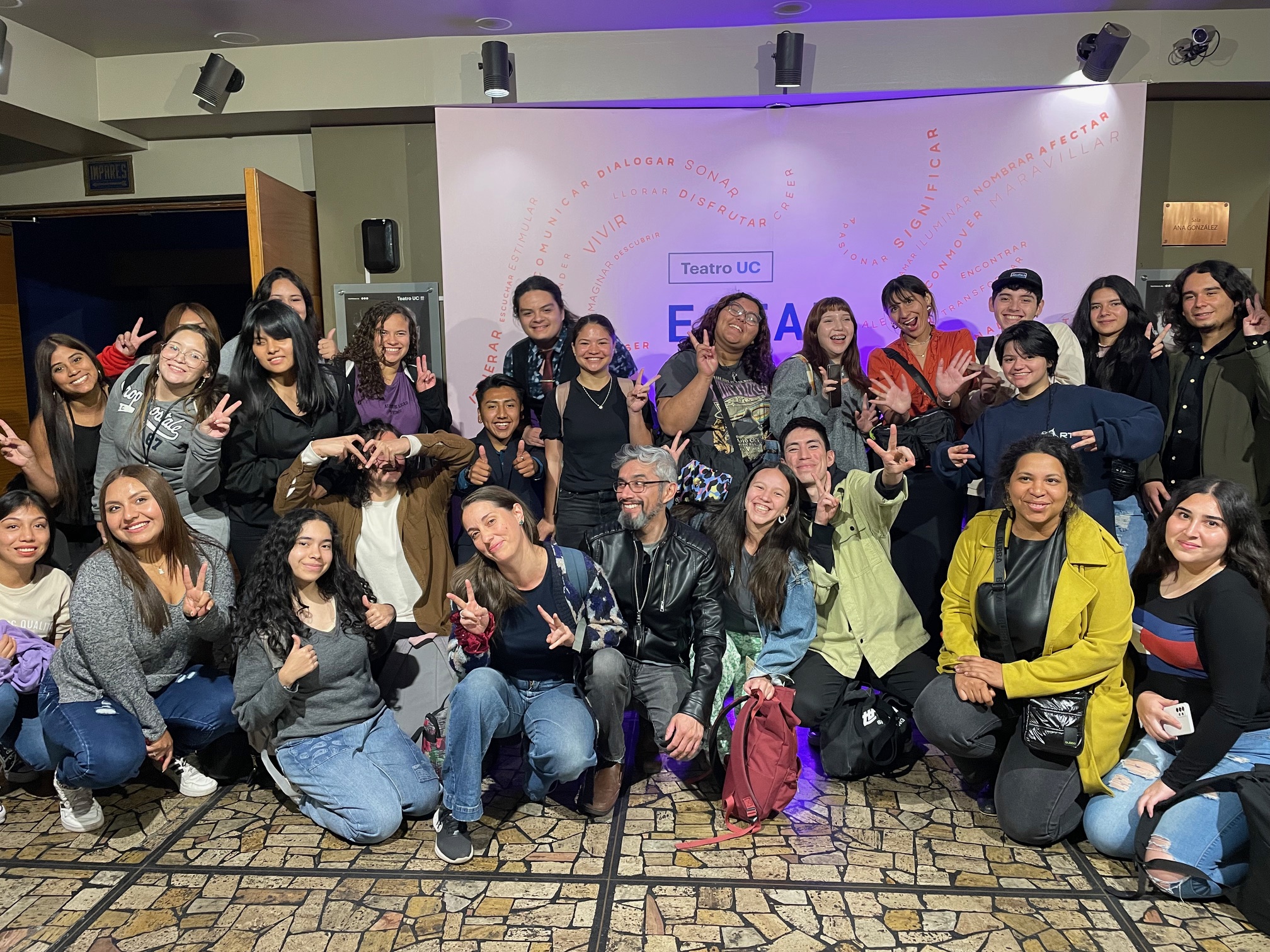 Estudiantes Educación Superior PACE UC y profesores posando de forma desordenada en el hall del Teatro UC
