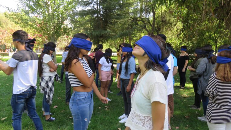 Estudiantes de primer año que ingresaron vía Cupo PACE UC en actividad de inserción en Campus San Joaquín, participando en una dinámica con vendas en sus ojos.