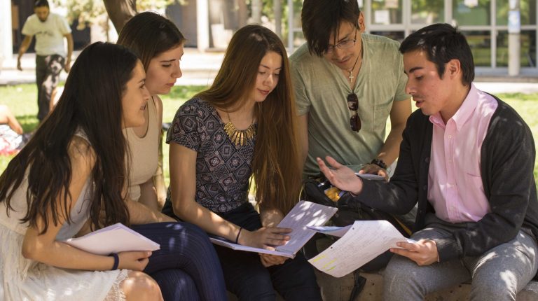 Se encuentra un grupo de estudiantes reunidos en patio.