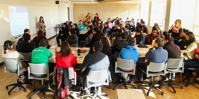 Grupo de profesores en taller dictado por PIANE. Se distribuyen en grupos sentados en distintas mesas.