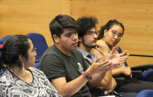 En la foto, se ven cuatro estudiantes UC conversando en encuentro intercultural, año 2019.