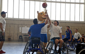 Pangui da inicio a partido de básquet adaptado lanzando pelota.
