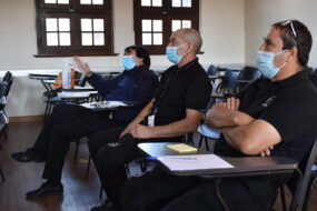 Guardias de seguridad de la UC sentados en sala de clases