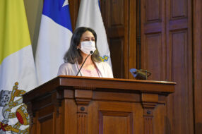 Fotografía de Catalina García en un podio con micrófono mirando hacia la derecha
