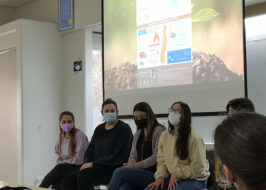 Fotografía de personas con mascarilla sentadas en sillas en una fila