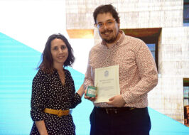 Fotografía de dos personas, una de ella sosteniendo un diploma