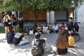 Foto de estudiantes UC reunidos y reunidas en un círculo