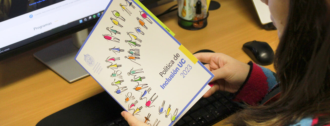 Persona sosteniendo copia física de la actualización de la Política de Inclusión UC 2023