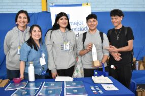 Profesionales PACE UC junto a estudiantes en entrega de regalo durante Feria Vocacional