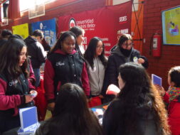 Estudiantes resolviendo dudas en stand de Ciencia 2030 UC
