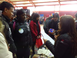 Estudiantes asistentes a la Feria Vocacional visitando stand de PACE UC y compartiendo con profesionales del equipo