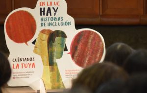 Pancarta de la convocatoria a participar en el primer Libro “Relatos de Inclusión en la UC”, con las frases “En la UC, hay historias de inclusión. Cuéntanos la tuya”, exhibida en el salón del lanzamiento del libro.